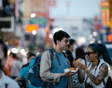Young tourists enjoy street food amidst bustling city vibes, capturing urban lifestyle.